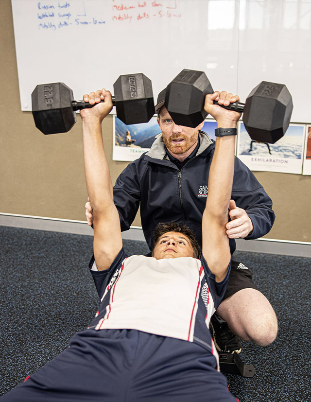 Santa Sophia Catholic College Box Hill student lifting weights under supervision of dedicated teacher