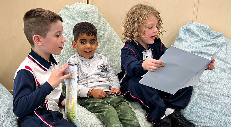 Santa Sophia Catholic College Box Hill students reading book to Early Learning student