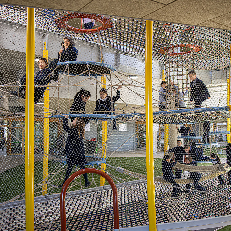Santa Sophia Catholic College Box Hill students playing on play equipment