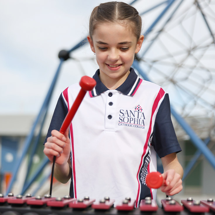 Santa Sophia Catholic College Box Hill student in sport uniform playing the xylophone